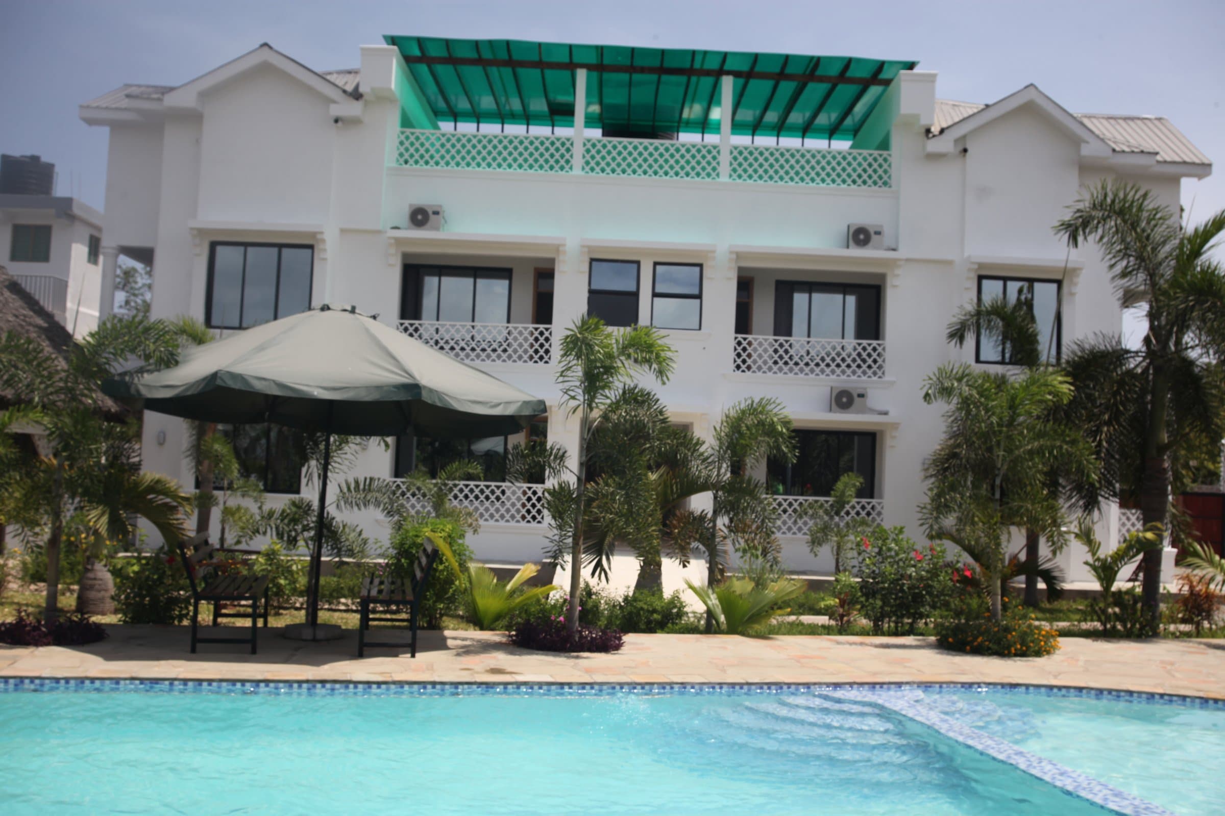 The main apartment building housing the Studio and One-Bedroom Apartments, with rooftop terrace and pool deck